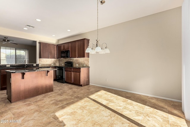 kitchen with a kitchen island, baseboards, a kitchen breakfast bar, decorative backsplash, and black appliances