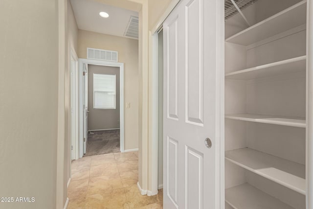 hallway with recessed lighting, visible vents, and baseboards