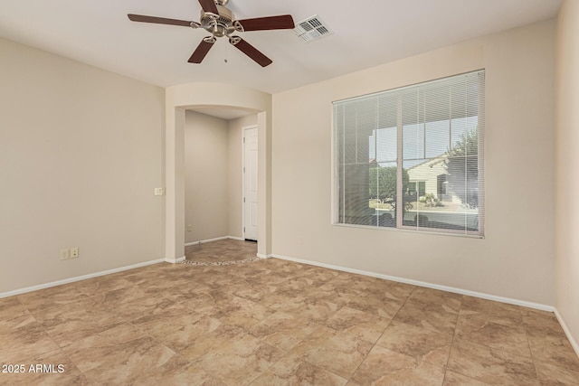 unfurnished room with baseboards, visible vents, and ceiling fan