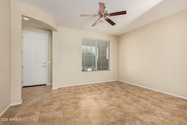 empty room featuring a ceiling fan and baseboards