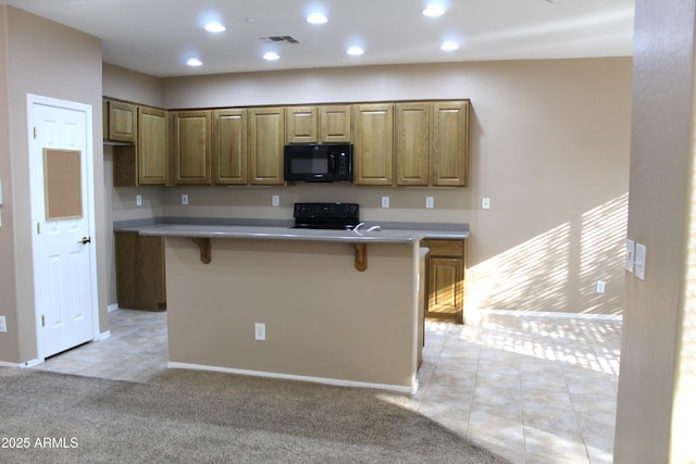 kitchen featuring light carpet, black appliances, a breakfast bar, and a center island