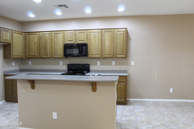 kitchen with black appliances and a kitchen bar