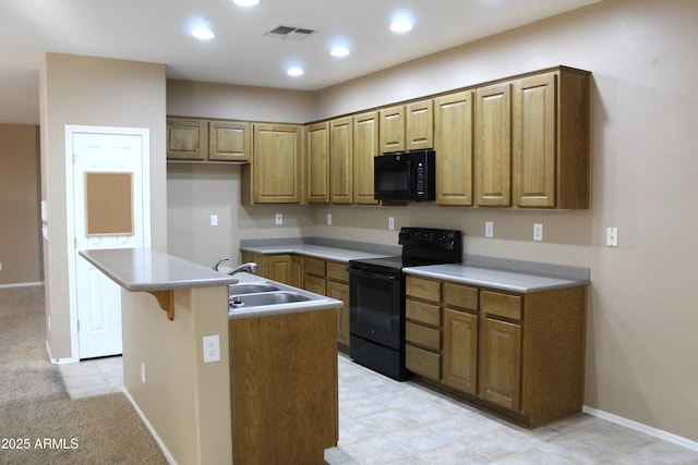 kitchen with sink, a center island with sink, a kitchen bar, and black appliances