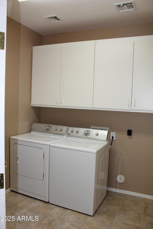 laundry area featuring washing machine and dryer and cabinets