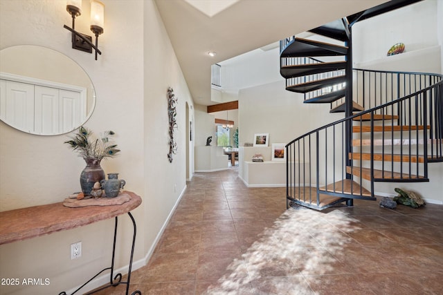 entrance foyer featuring stairway and baseboards