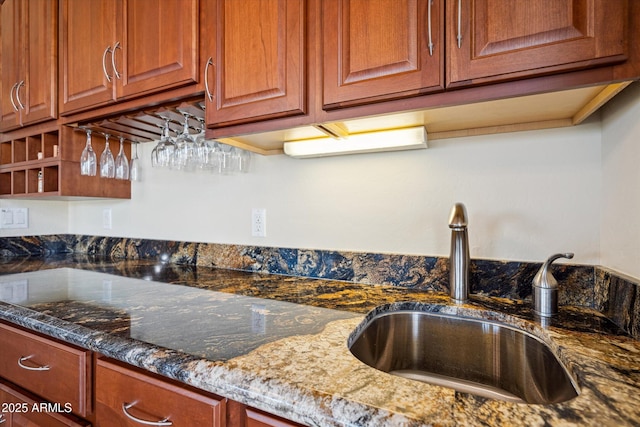 kitchen featuring dark stone counters, open shelves, and a sink