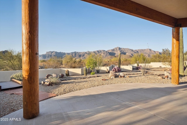 view of patio with a mountain view and fence