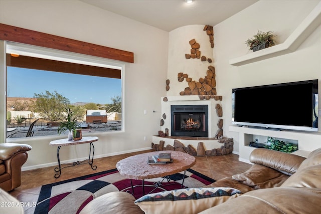 living room with tile patterned floors, baseboards, and a lit fireplace