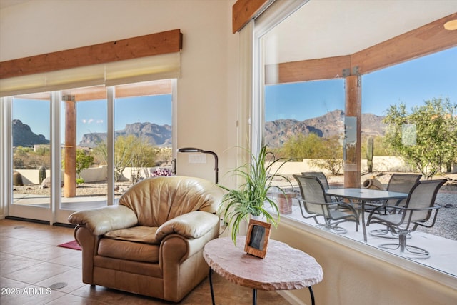 living area with a mountain view, a healthy amount of sunlight, and tile patterned flooring