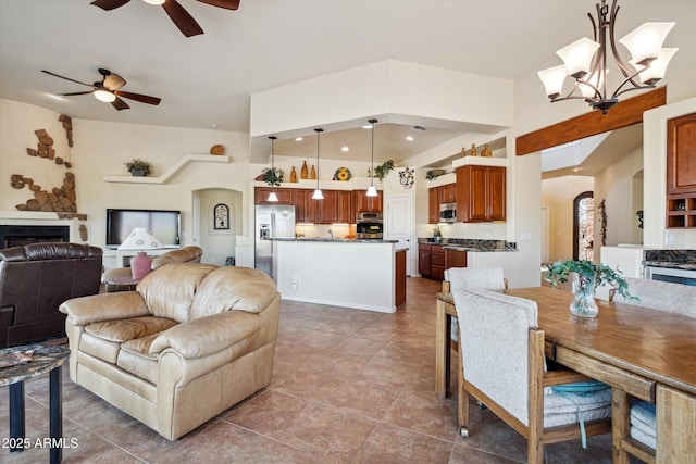 interior space with arched walkways and ceiling fan with notable chandelier