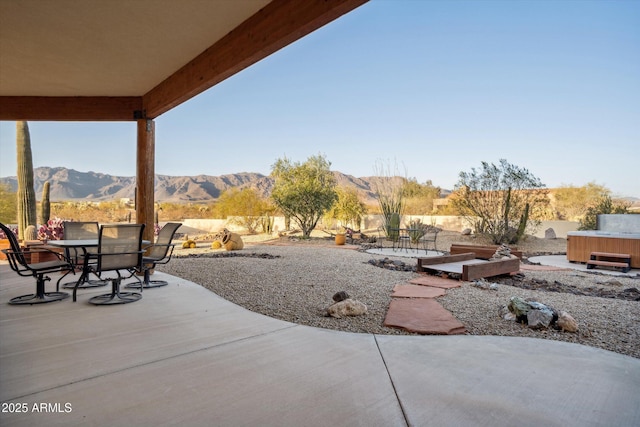 view of patio / terrace featuring a mountain view, outdoor dining area, and fence