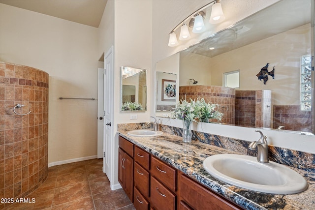 bathroom with double vanity, tile patterned flooring, a walk in shower, and a sink