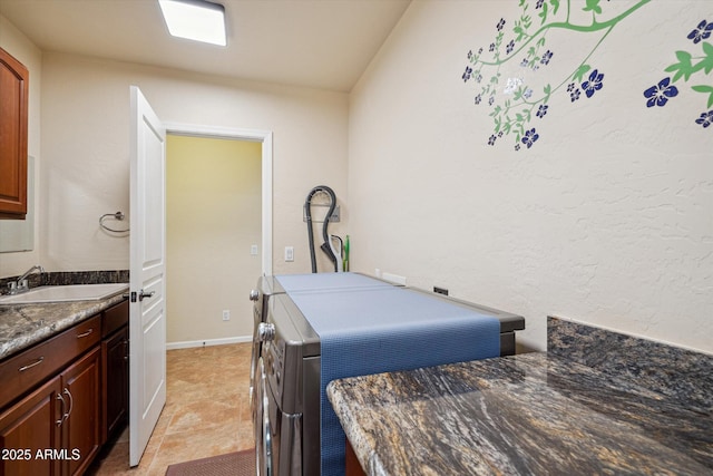 interior space with cabinet space, separate washer and dryer, baseboards, and a sink