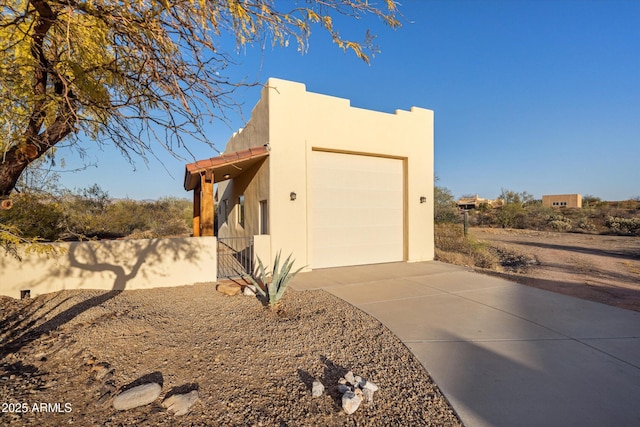 view of side of property featuring concrete driveway and an attached garage