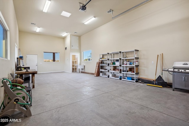 garage with visible vents, baseboards, and a garage door opener