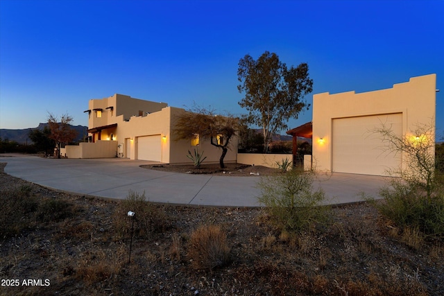 view of home's exterior with stucco siding, an attached garage, and driveway