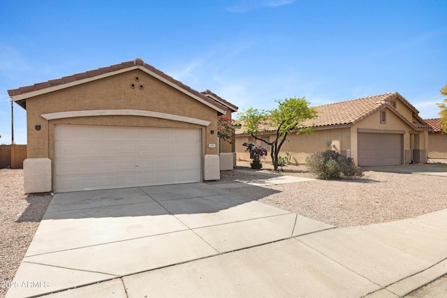 single story home featuring stucco siding, a tiled roof, and driveway