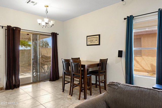dining room with a chandelier and light tile patterned flooring