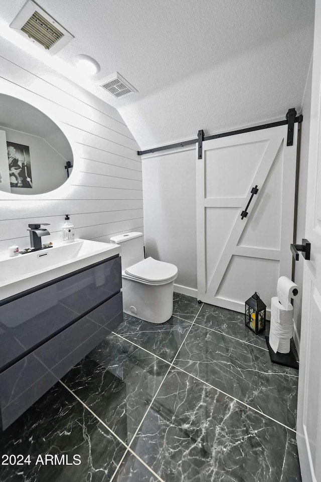 bathroom with vanity, a textured ceiling, wood walls, toilet, and lofted ceiling