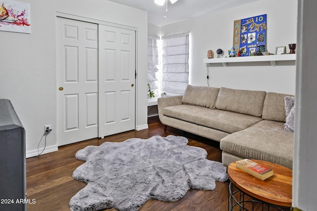 living room featuring dark wood-type flooring and ceiling fan