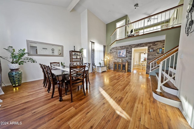 dining area featuring high vaulted ceiling, beamed ceiling, and hardwood / wood-style floors