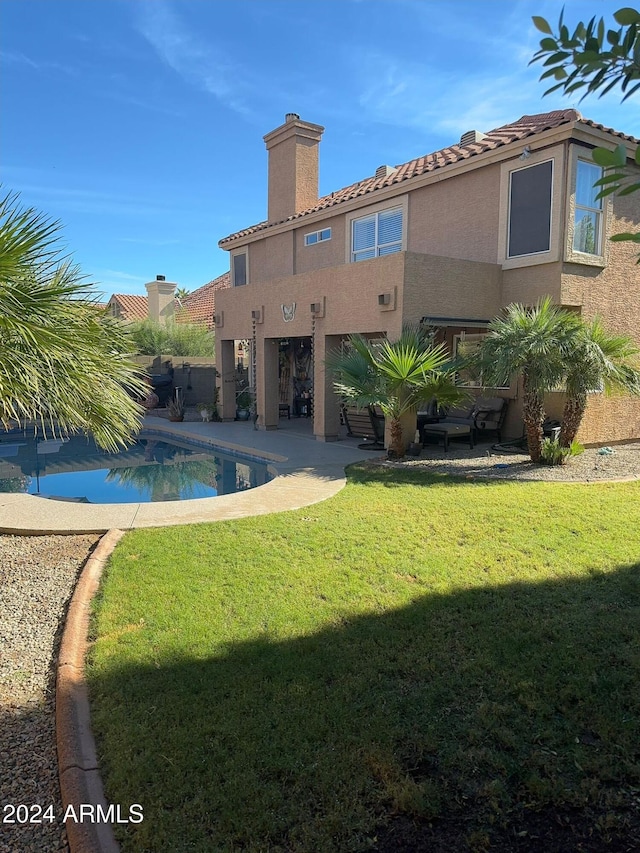 rear view of house featuring a yard and a patio area