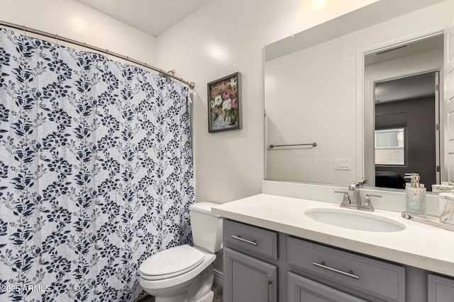 bathroom with vanity, toilet, and curtained shower