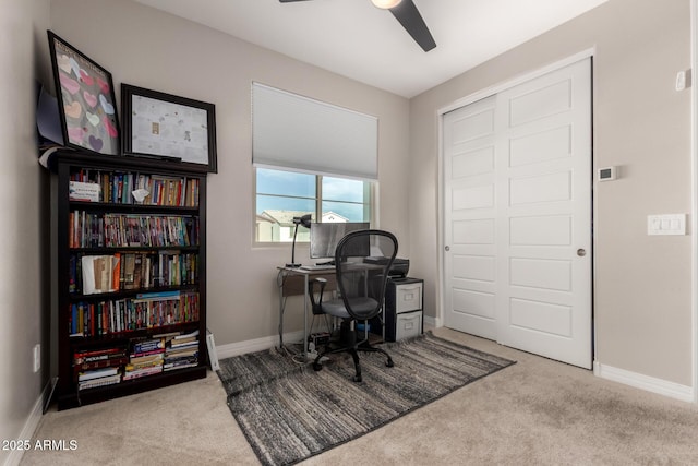 carpeted home office featuring ceiling fan