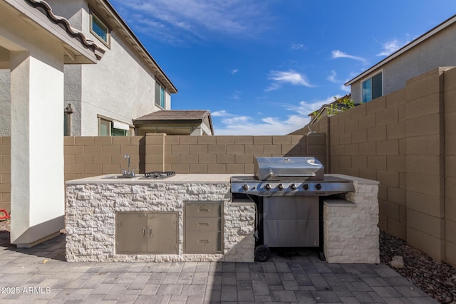 view of patio / terrace featuring an outdoor kitchen, sink, and area for grilling