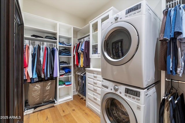 laundry room with light wood-style floors, stacked washer and clothes dryer, and laundry area