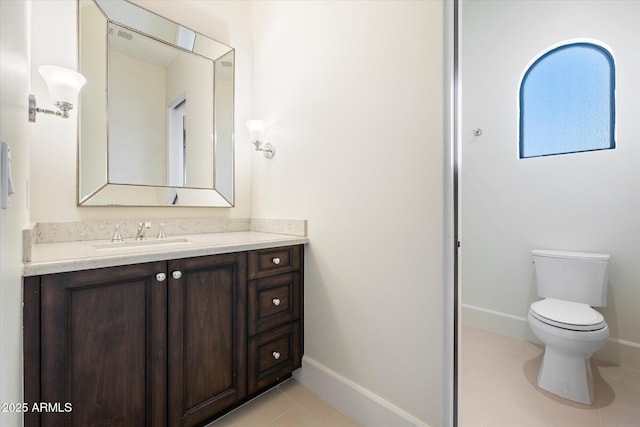 bathroom with baseboards, vanity, toilet, and tile patterned floors