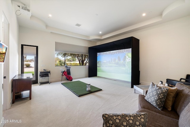 interior space featuring a tray ceiling, baseboards, visible vents, and golf simulator