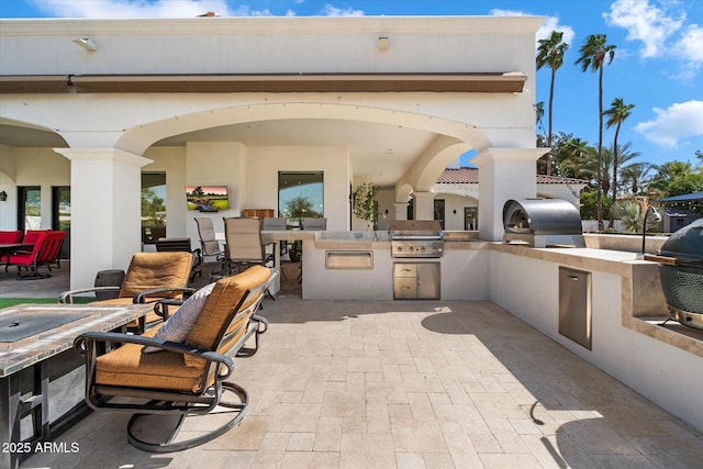 view of patio with area for grilling and a grill