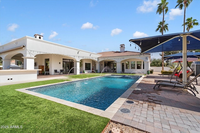 pool with a lawn and a patio area