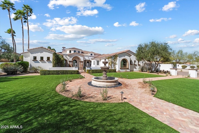 view of front of house with a tiled roof, a front lawn, and stucco siding