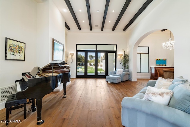 interior space with arched walkways, baseboards, french doors, beamed ceiling, and wood-type flooring