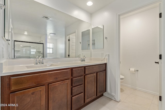 bathroom with vanity, toilet, tile patterned flooring, and an enclosed shower