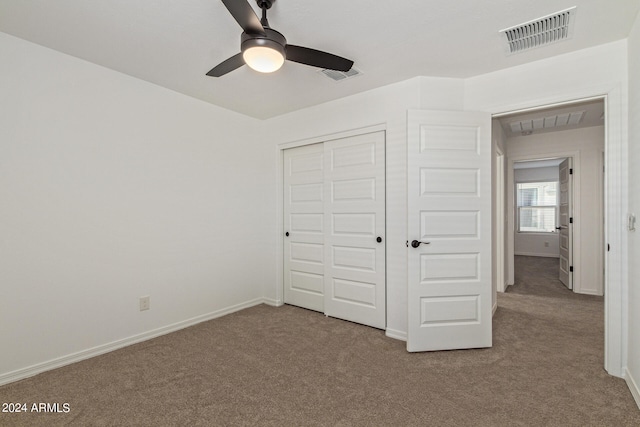 unfurnished bedroom featuring light colored carpet, a closet, and ceiling fan