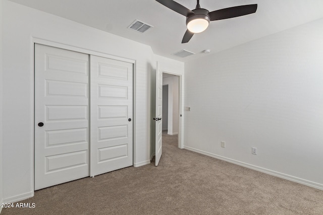 unfurnished bedroom featuring light carpet, a closet, and ceiling fan