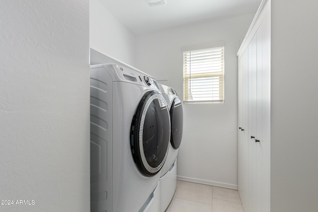 clothes washing area featuring washer and dryer and light tile patterned flooring