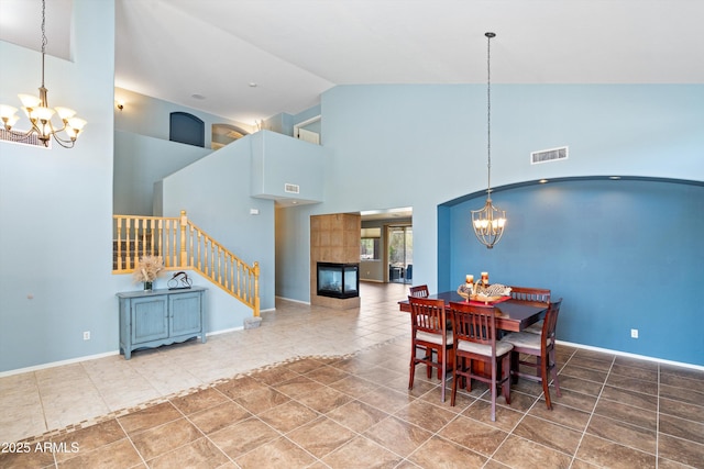 dining room featuring tile patterned floors, visible vents, a chandelier, and stairs