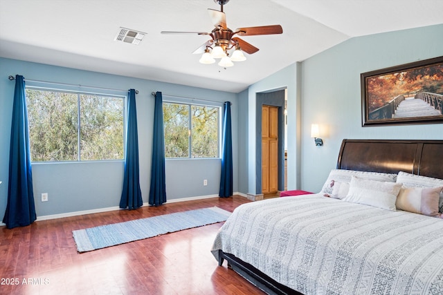 bedroom featuring visible vents, lofted ceiling, baseboards, and wood finished floors