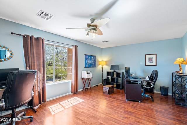 office area with a ceiling fan, wood finished floors, and visible vents