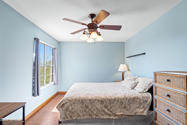 bedroom featuring a ceiling fan, wood finished floors, and baseboards