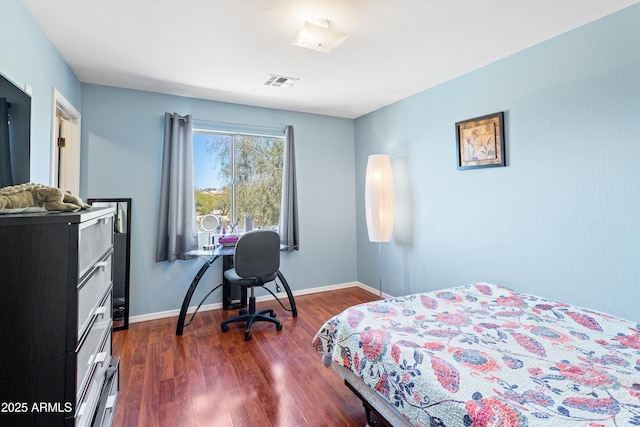 bedroom with dark wood-style floors, visible vents, and baseboards