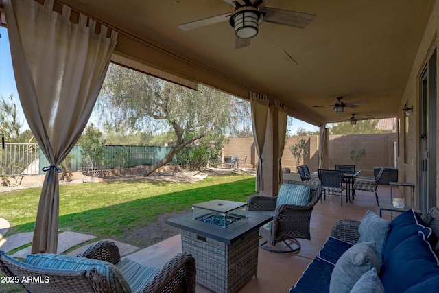 view of patio / terrace featuring outdoor dining space, a ceiling fan, a fenced backyard, and an outdoor living space with a fire pit