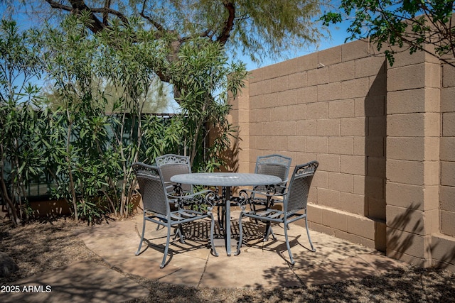 view of patio featuring outdoor dining area and fence