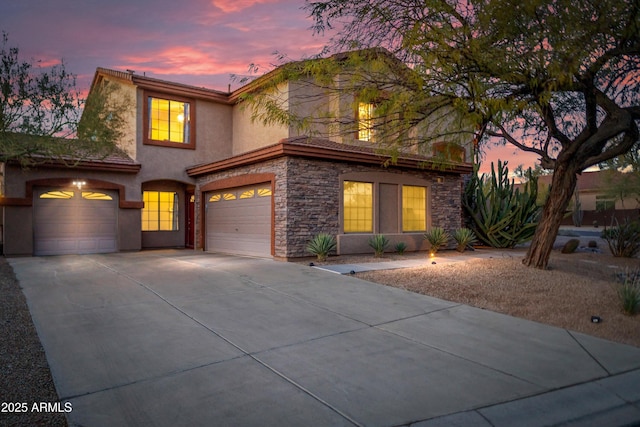 view of front facade with stone siding, stucco siding, and driveway