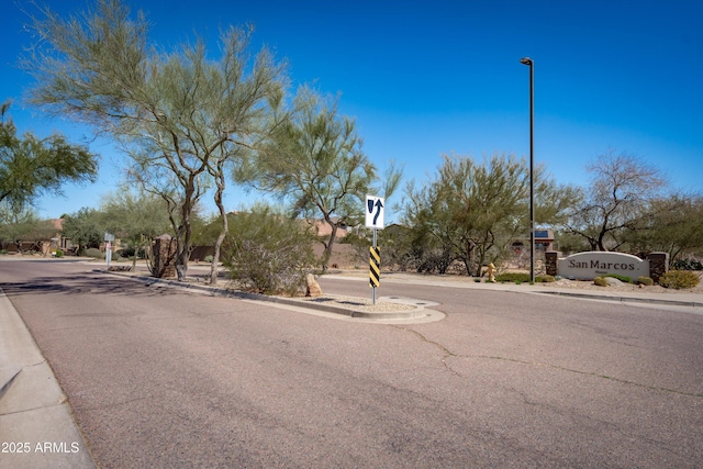 view of street featuring curbs, sidewalks, and street lighting