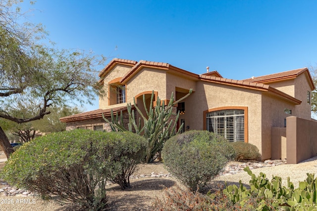 mediterranean / spanish house with a tiled roof and stucco siding